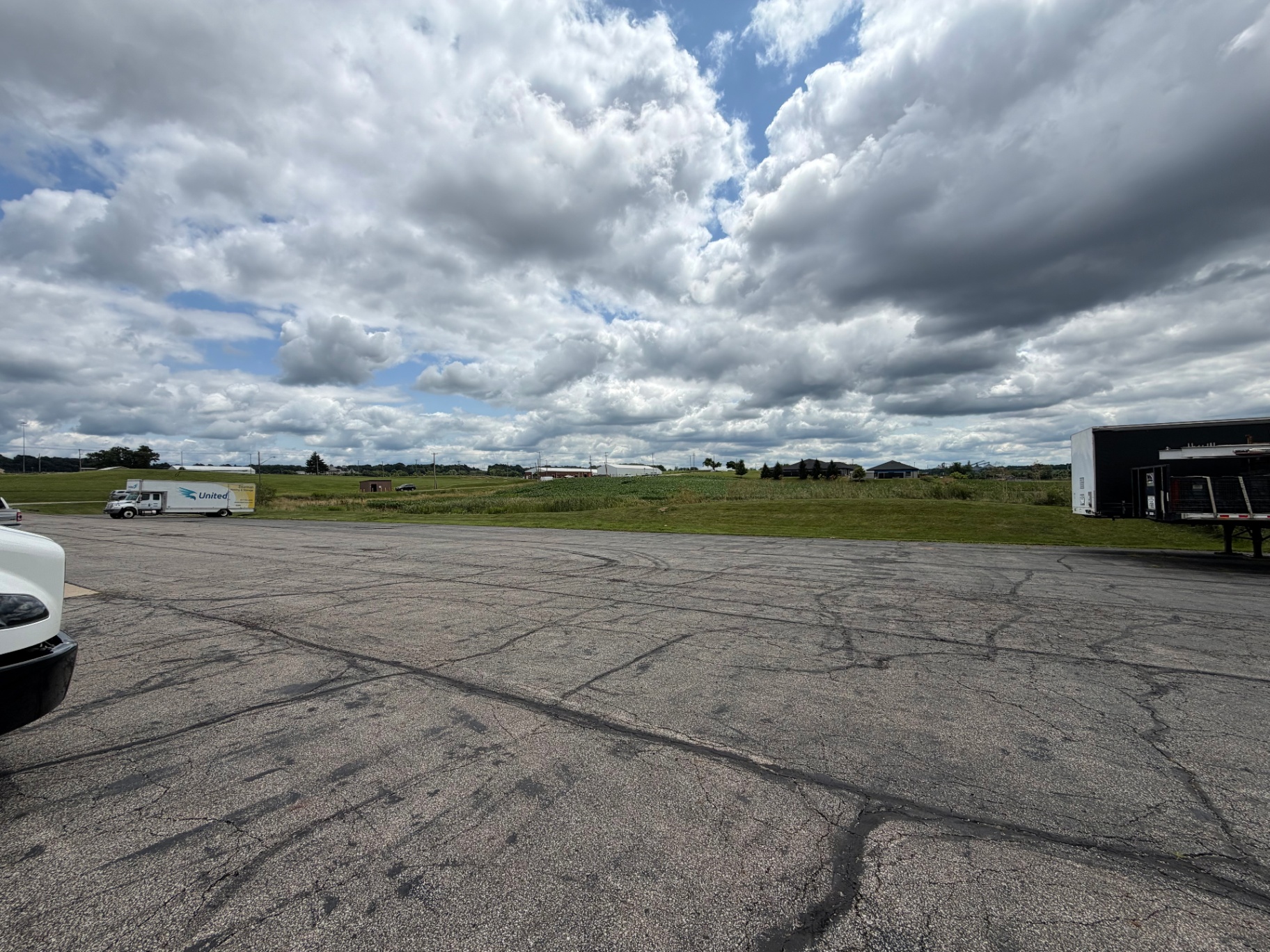 Wide paved lot at the Mansfield facility with a United moving truck and open sky
