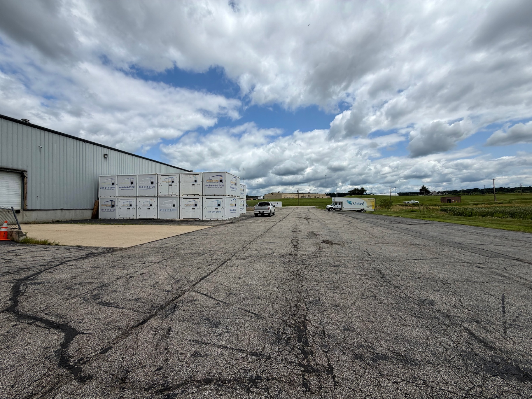 Paved outdoor lot with stacked MobiStor portable storage containers next to the warehouse