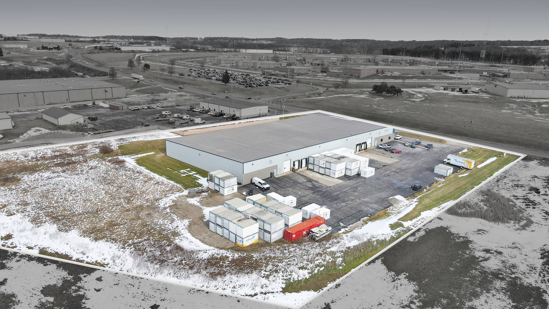 Aerial view of the Mansfield facility showing the warehouse building alongside a paved outdoor lot with portable storage containers and trailers