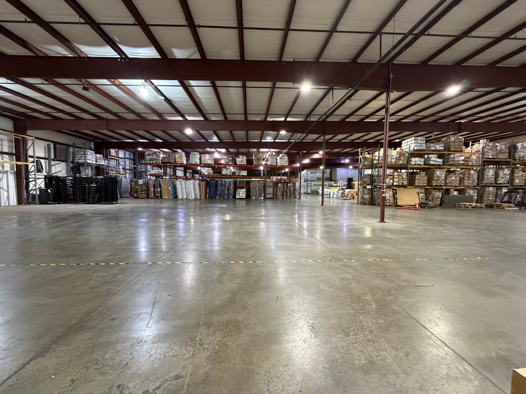 Warehouse interior with pallet racks stocked with inventory and open staging floor