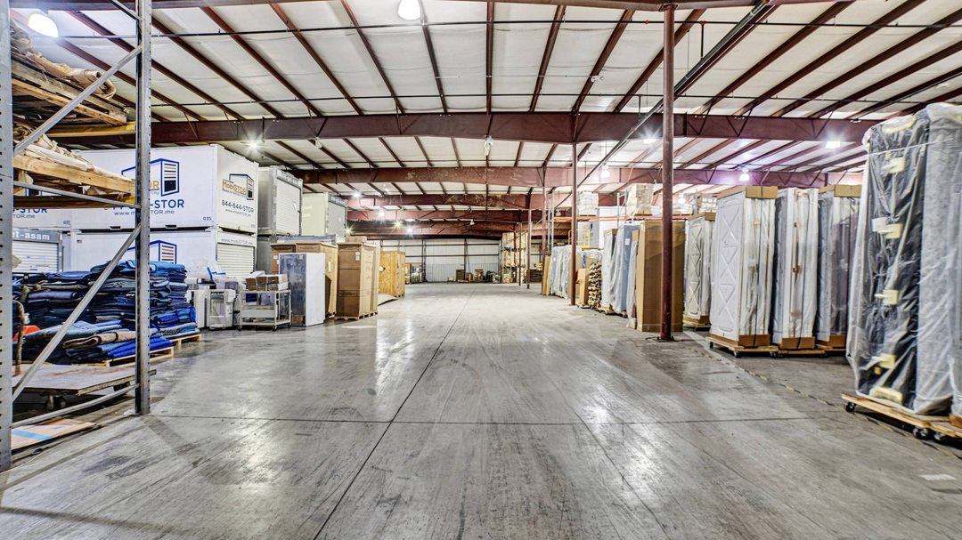 Wide interior aisle of MobiStor's heated warehouse lined with portable storage containers and palletized goods