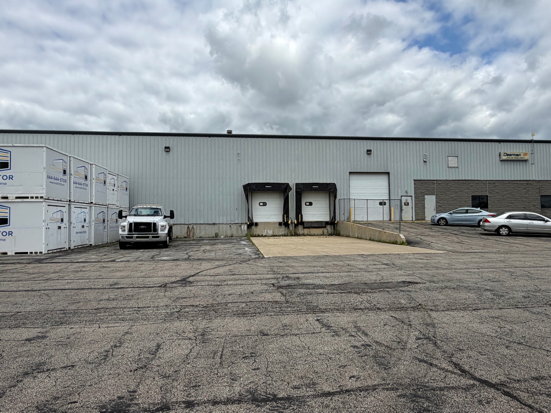 Loading dock doors at the Mansfield warehouse with stacked containers and a service truck